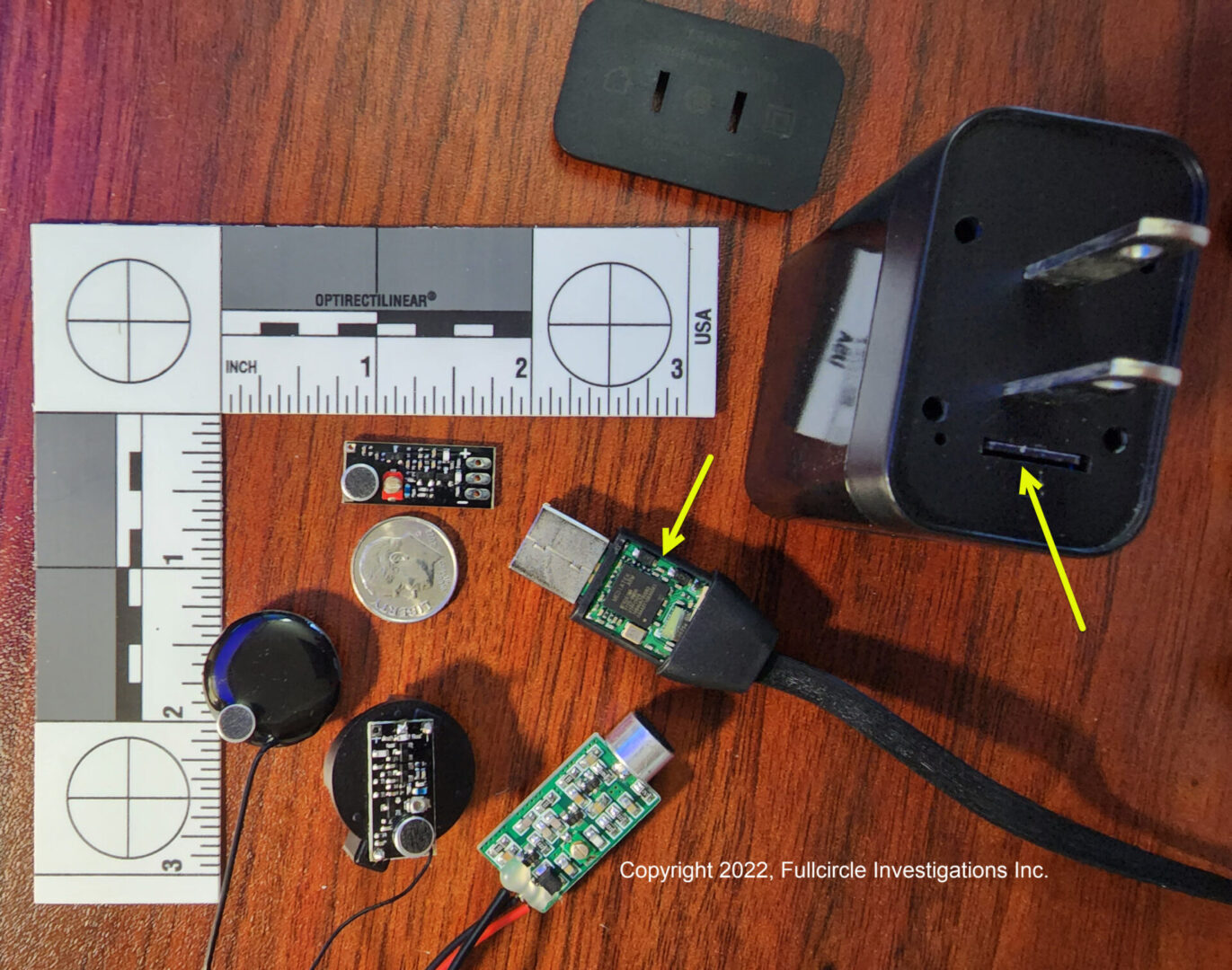 A table with several electronic devices and some rulers.