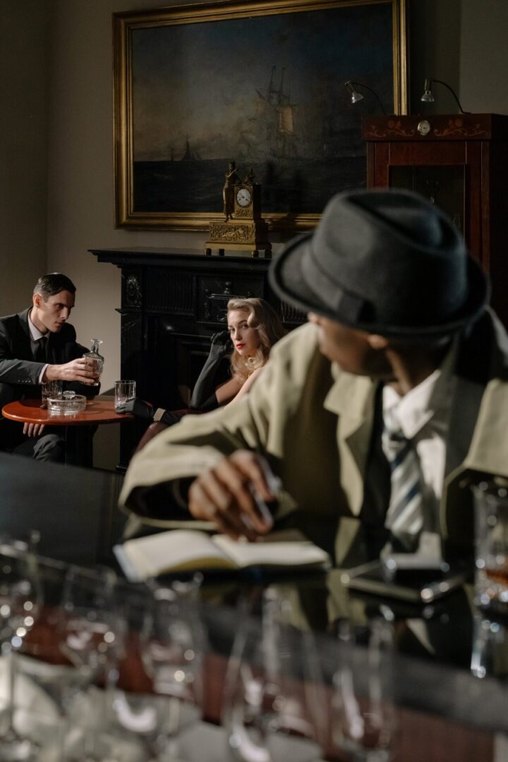 A man in a hat and jacket sitting at a table with two women.